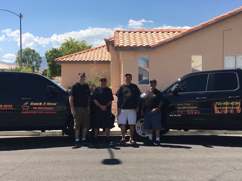 4 men standing in front of a truck with a trailer.