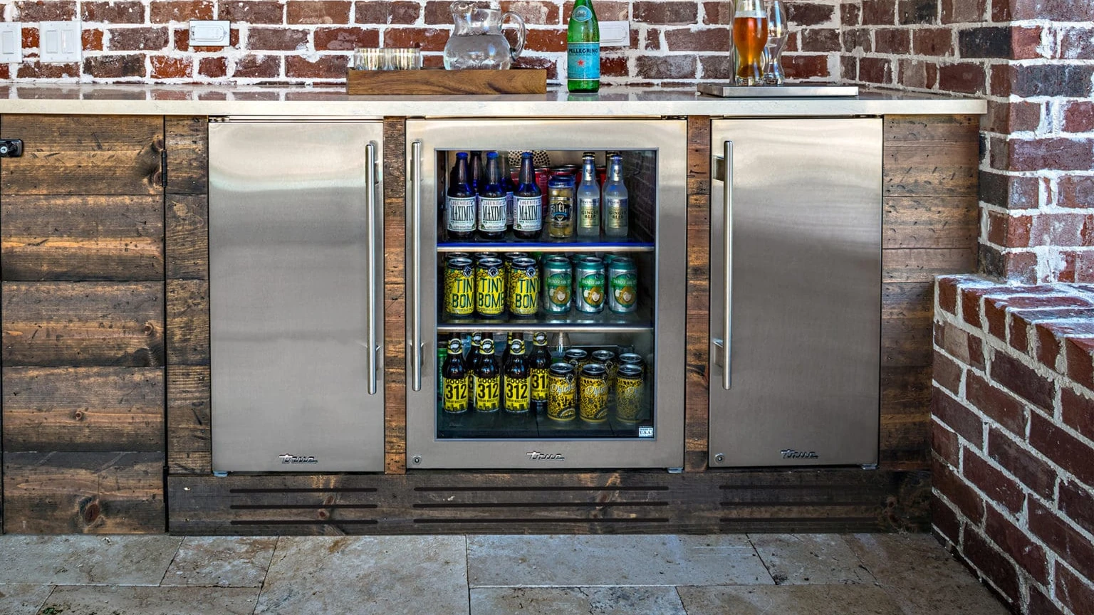 A mini-fridge that is part of an outdoor island.
